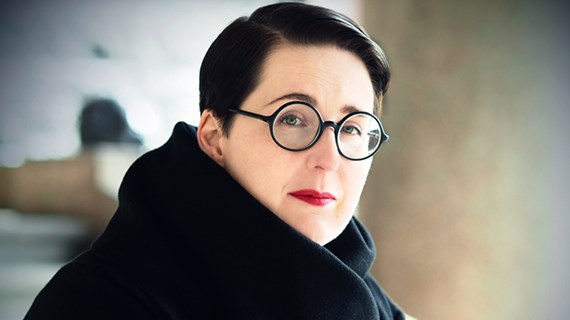 Karin Tidbeck i svart päls och runda svarta glasögon.