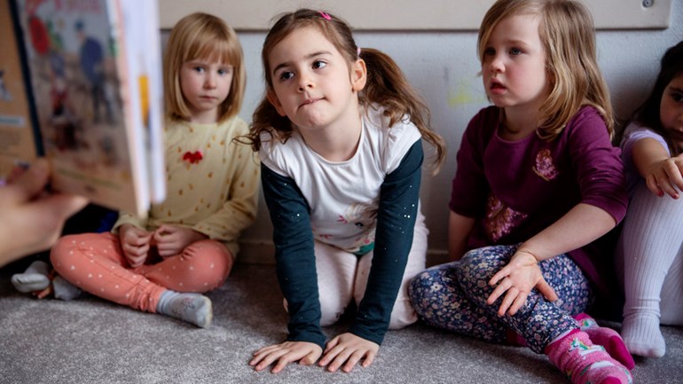 Barn på förskola lyssnar på högläsning.