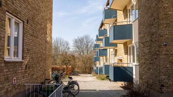 Hus med tegelfasad och blå balkonger.