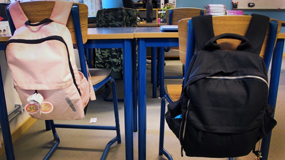 Närbild ryggsäckar i klassrum.