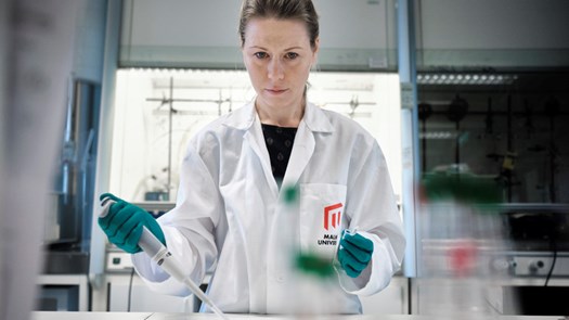 Forskare i labbmiljö gör arbete med pipett och provrör. 