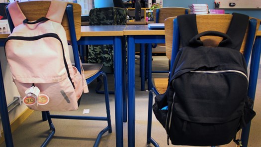 Närbild ryggsäckar i klassrum.