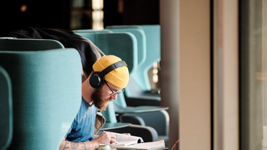 Student studerar framför fönster.