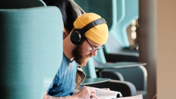 Student studerar framför fönster.