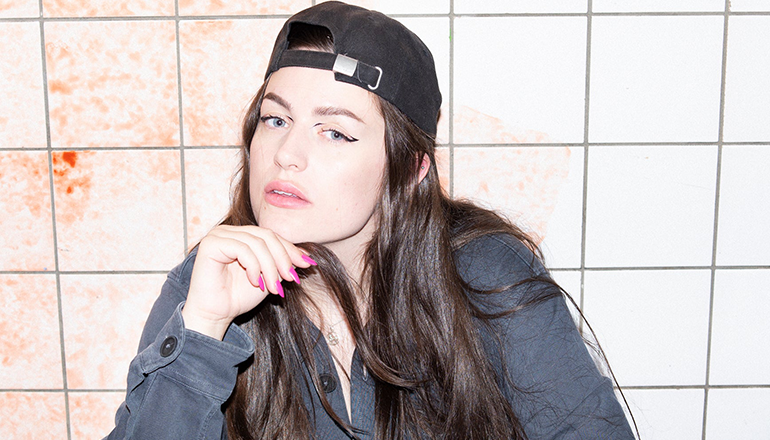 Moa Romanova in a cap and hoodie