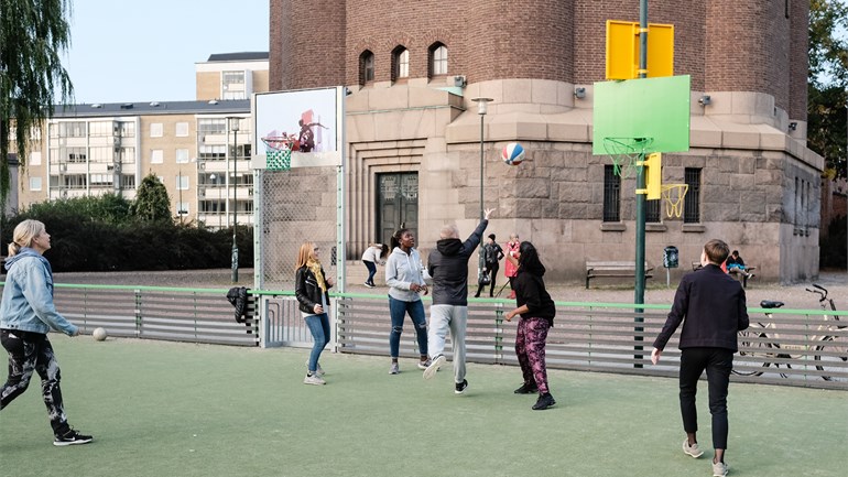 Unga personer spelar basket utomhus